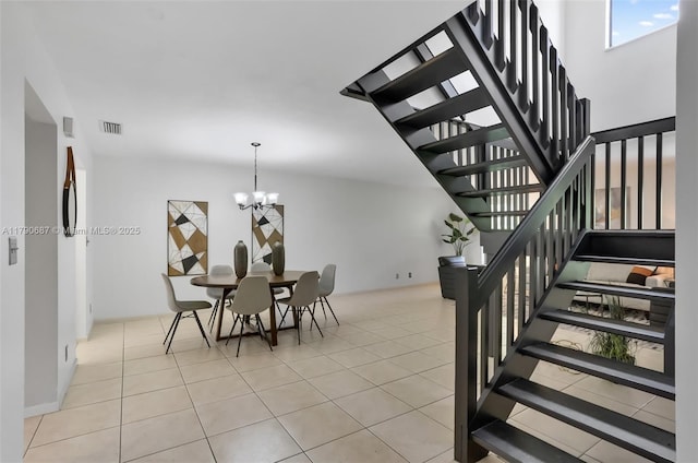 tiled dining room with a chandelier, visible vents, and stairs