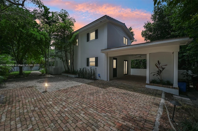 4700 Alhambra Cir, Coral Gables, FL 33146 - back of house at dusk featuring stucco siding and fence