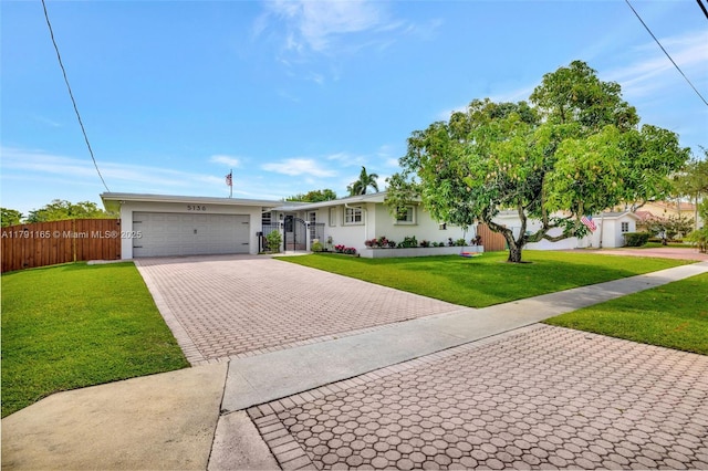 ranch-style home with stucco siding, fence, driveway, a front yard, and an attached garage