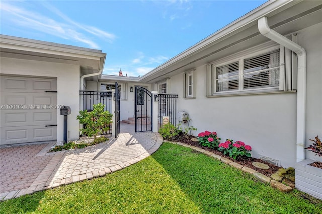 doorway to property featuring stucco siding, a gate, and an attached garage