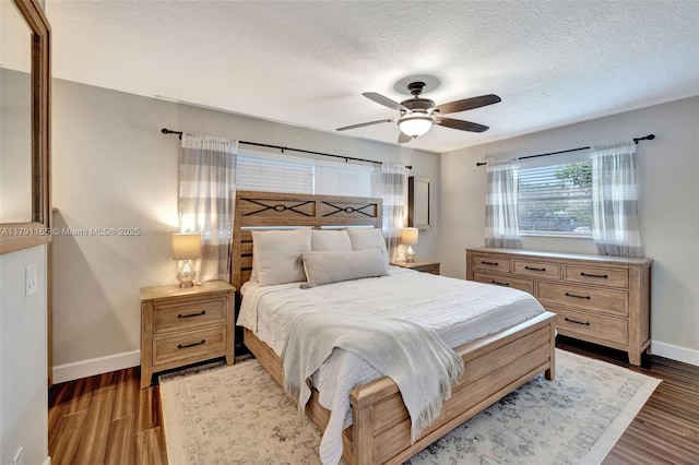 bedroom featuring a textured ceiling, wood finished floors, ceiling fan, and baseboards