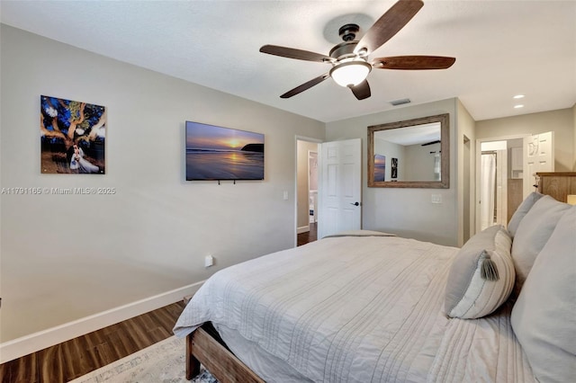 bedroom featuring a ceiling fan, visible vents, wood finished floors, and baseboards