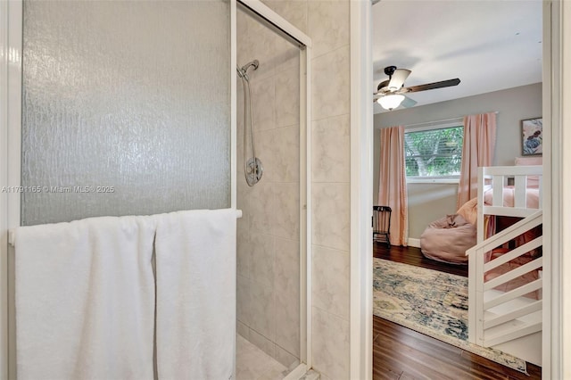 full bathroom with wood finished floors, a shower stall, connected bathroom, and ceiling fan