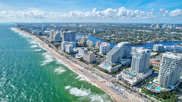 drone / aerial view with a water view, a city view, and a view of the beach
