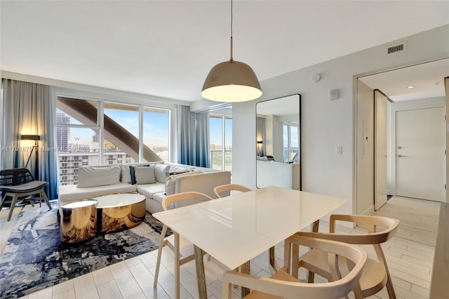 dining room with visible vents, a healthy amount of sunlight, and light wood-style floors