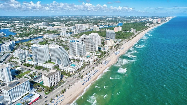 drone / aerial view featuring a view of city, a beach view, and a water view
