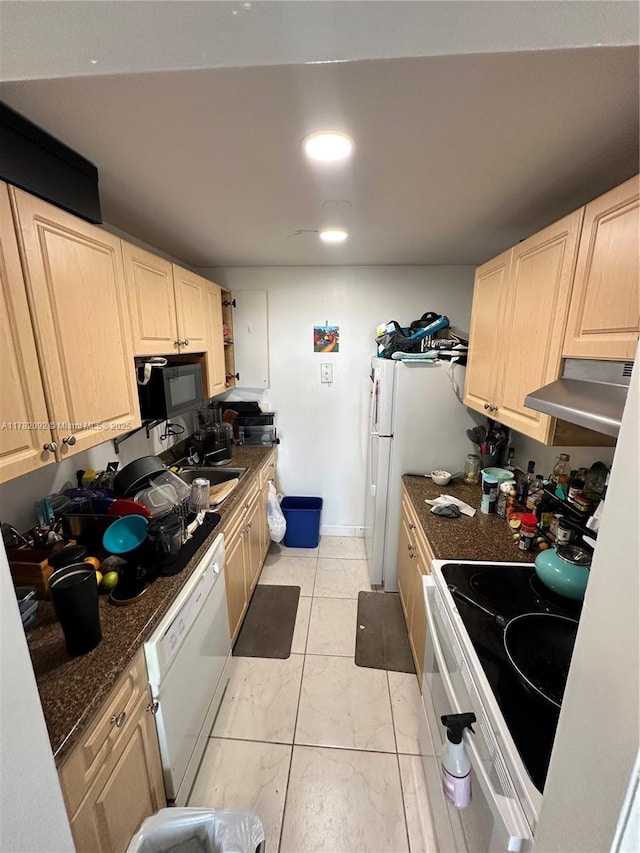 kitchen featuring light brown cabinets, under cabinet range hood, and white appliances