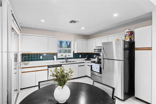 2215 SE 7th Pl, Homestead, FL 33033 - kitchen featuring white cabinets, tasteful backsplash, appliances with stainless steel finishes, and a sink