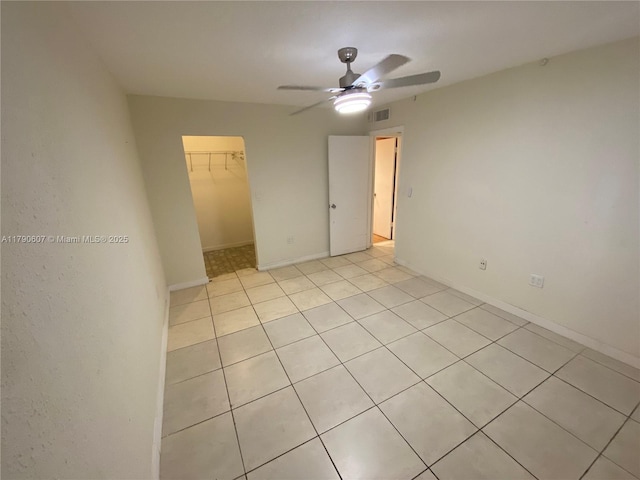 unfurnished room featuring baseboards, visible vents, light tile patterned floors, and ceiling fan