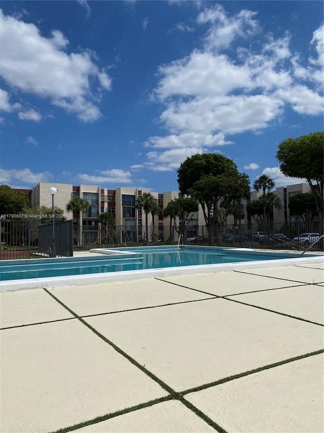 pool with fence and a patio area
