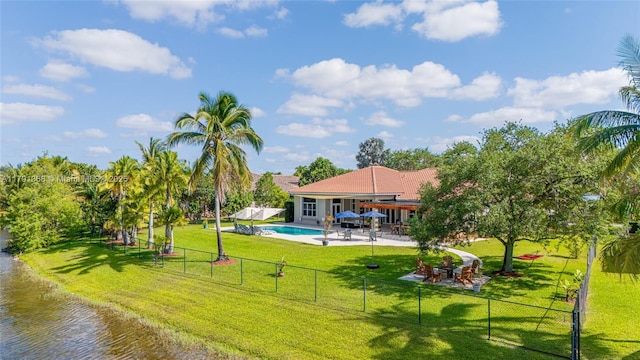 exterior space featuring a patio area, a fenced in pool, a yard, a water view, and a fenced backyard