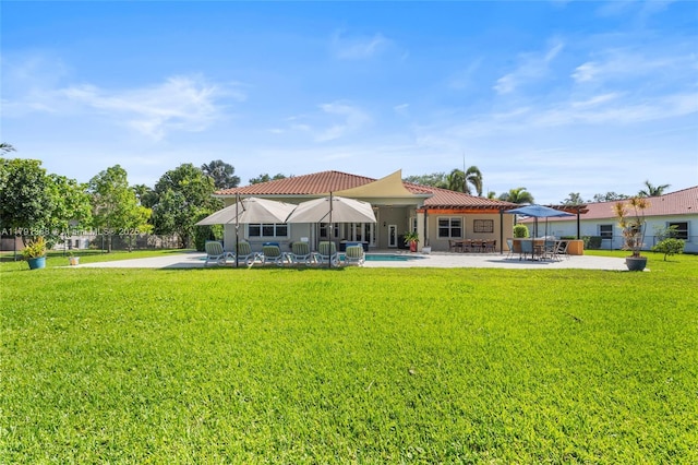 rear view of house featuring fence, a patio area, and a yard