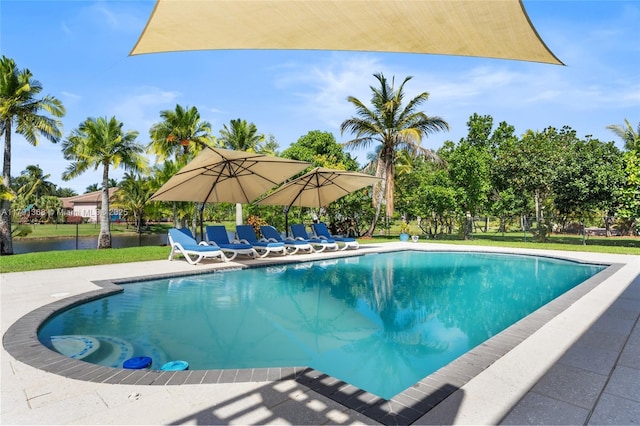 outdoor pool with fence, a lawn, and a patio