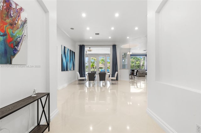 corridor with baseboards, recessed lighting, ornamental molding, and french doors