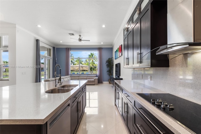 kitchen featuring a sink, crown molding, black electric stovetop, and wall chimney exhaust hood