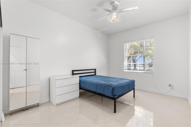 bedroom with light tile patterned floors, ceiling fan, and baseboards