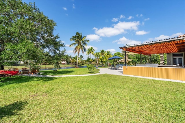 view of yard featuring fence, a water view, and a patio