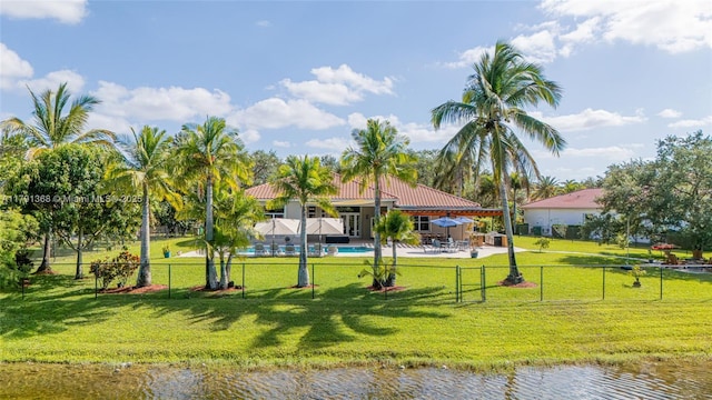 view of property's community with a patio, a water view, a lawn, fence, and a pool