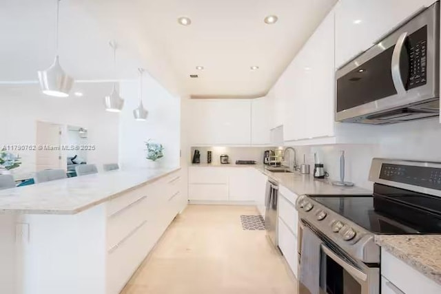 kitchen with white cabinets, a sink, appliances with stainless steel finishes, modern cabinets, and a peninsula