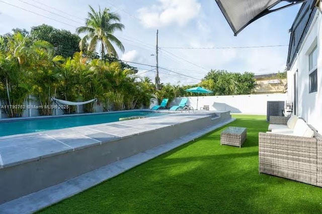 view of swimming pool with a fenced backyard, a yard, central air condition unit, and a fenced in pool