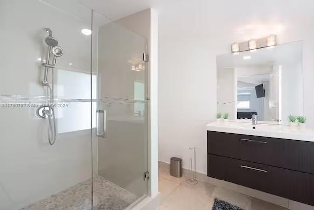 bathroom with tile patterned floors, vanity, and a shower stall
