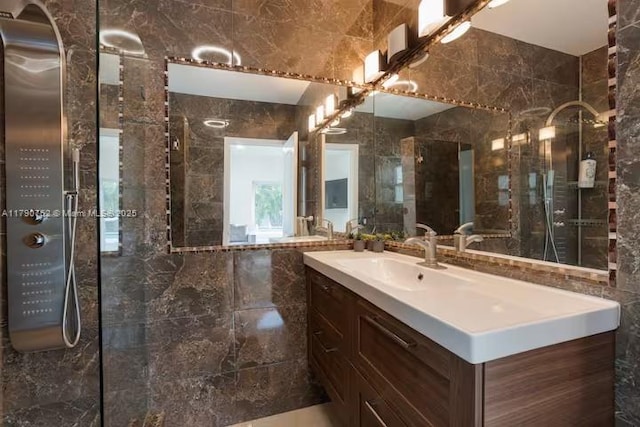 full bathroom with vanity, tiled shower, and tile walls
