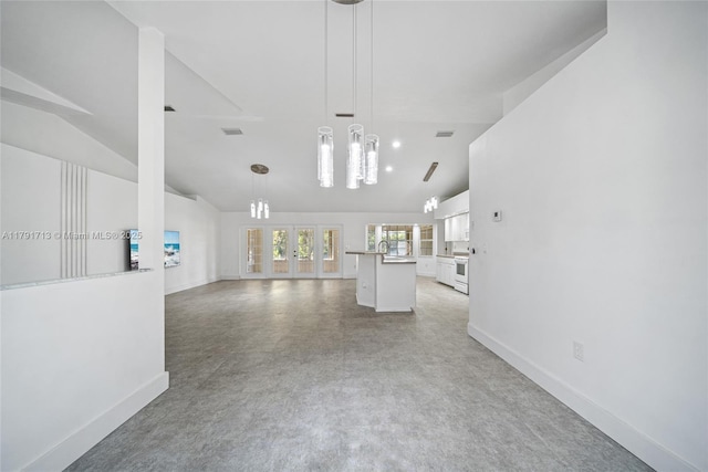 unfurnished living room featuring baseboards, visible vents, an inviting chandelier, and vaulted ceiling