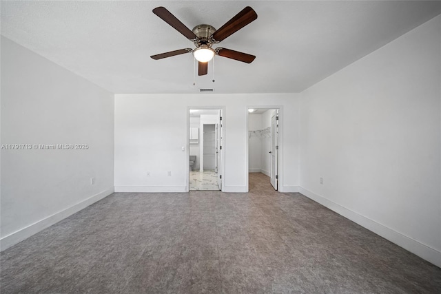 unfurnished bedroom featuring visible vents, a closet, baseboards, a spacious closet, and a ceiling fan
