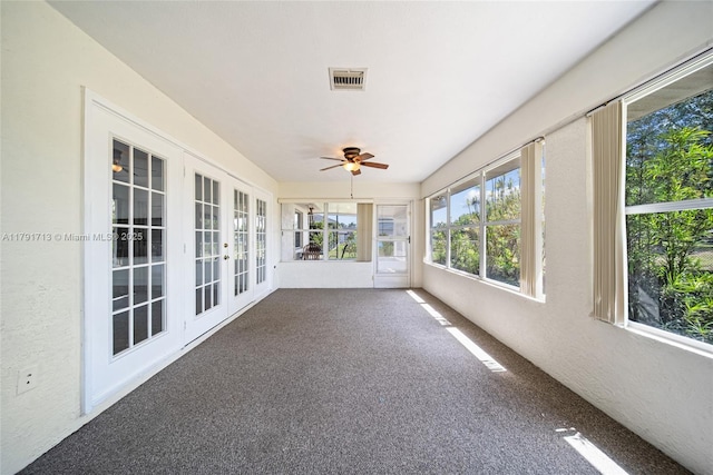 unfurnished sunroom featuring visible vents, ceiling fan, carpet floors, and french doors