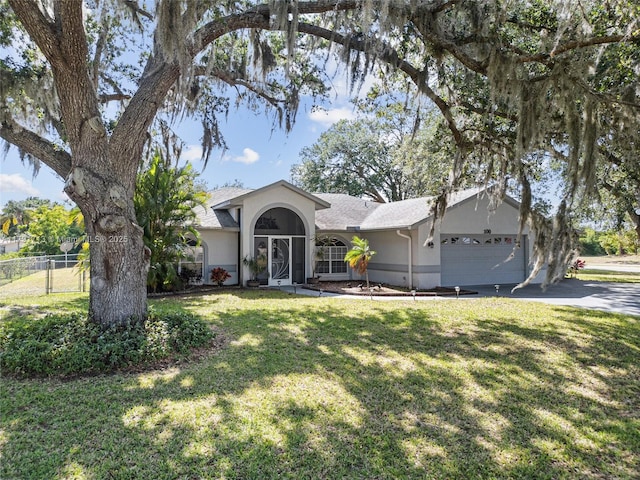 single story home featuring a front lawn, stucco siding, driveway, an attached garage, and fence