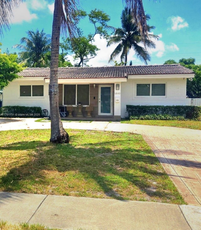 1540 NE 173rd St, North Miami Beach, FL 33162 - ranch-style home with a tiled roof, a front lawn, and stucco siding