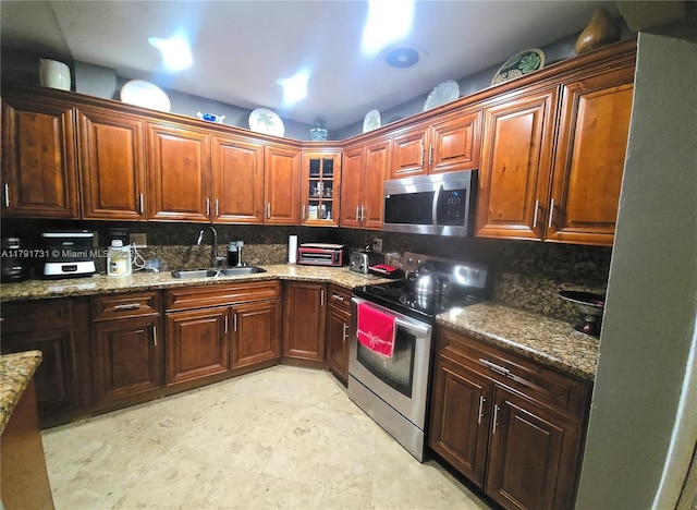 1540 NE 173rd St, North Miami Beach, FL 33162 - kitchen with appliances with stainless steel finishes, a sink, decorative backsplash, and glass insert cabinets