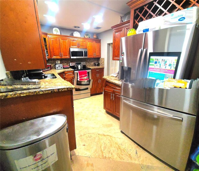 1540 NE 173rd St, North Miami Beach, FL 33162 - kitchen featuring appliances with stainless steel finishes, decorative backsplash, light stone countertops, and brown cabinets
