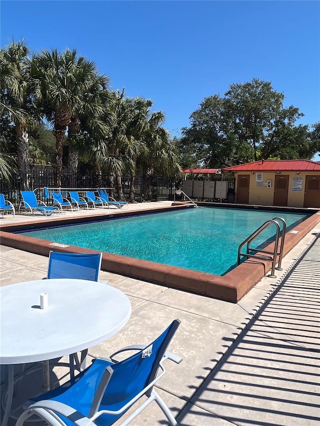 pool with fence and a patio area