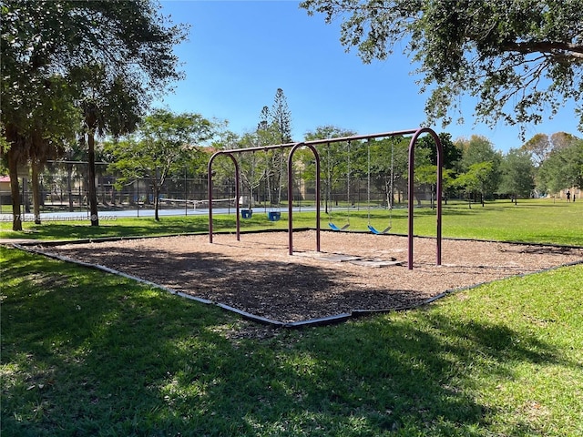 community jungle gym with a lawn and fence