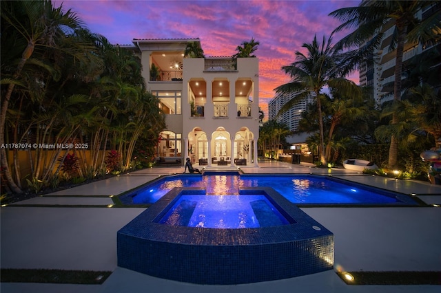 outdoor pool with a patio, french doors, and an in ground hot tub