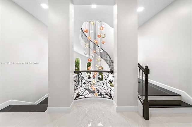 staircase with an inviting chandelier, recessed lighting, tile patterned flooring, and baseboards