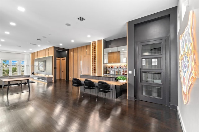 bar featuring bar, visible vents, baseboards, recessed lighting, and wood finished floors