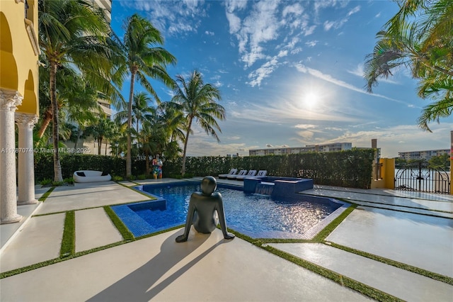 view of pool with fence, a gate, a patio area, and a pool with connected hot tub