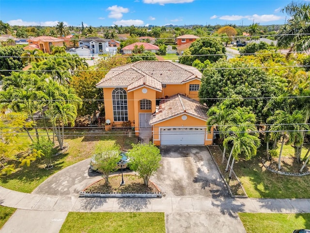 mediterranean / spanish-style home featuring driveway, fence, a tiled roof, stucco siding, and a garage