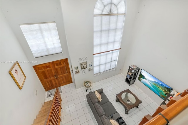 foyer with light tile patterned flooring and a towering ceiling
