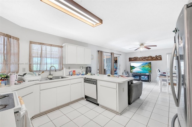 kitchen featuring stove, a ceiling fan, dishwashing machine, a peninsula, and freestanding refrigerator