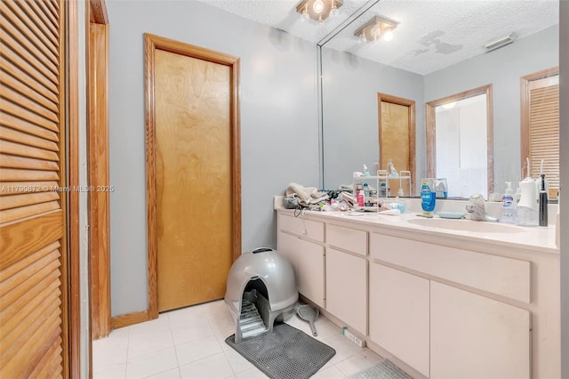 full bathroom with tile patterned flooring, a closet, vanity, visible vents, and a textured ceiling