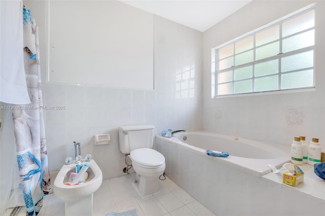 bathroom with tile walls, a bath, toilet, tile patterned flooring, and a bidet