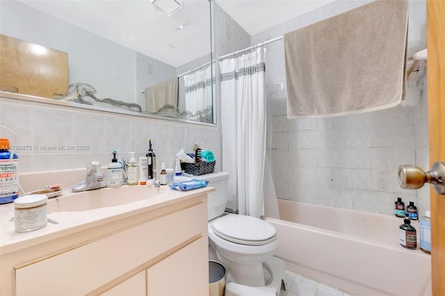 bathroom with tile walls, shower / bath combo, vanity, toilet, and tile patterned flooring