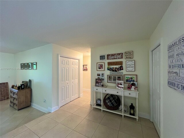 14051 SW 15th Ct, Davie, FL 33325 - hallway featuring light tile patterned flooring and baseboards