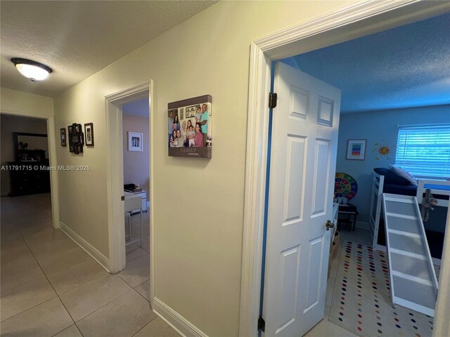 14051 SW 15th Ct, Davie, FL 33325 - corridor featuring a textured ceiling, light tile patterned floors, and baseboards