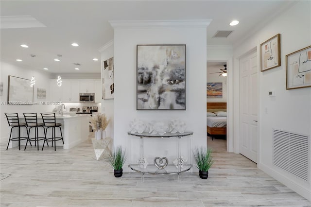 26047 SW Viterbo Way, Port St Lucie, FL 34986 - corridor featuring visible vents, light wood-style floors, crown molding, and recessed lighting