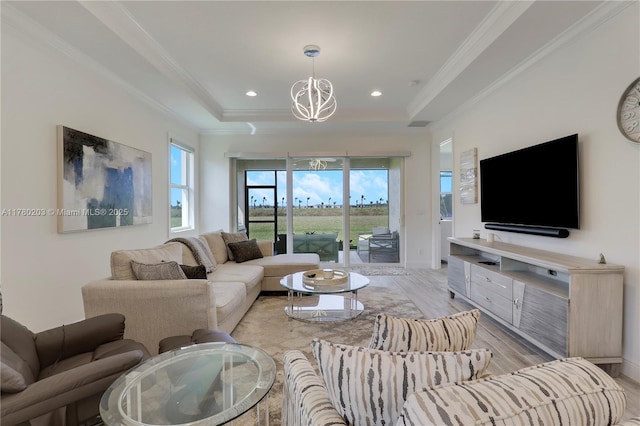 26047 SW Viterbo Way, Port St Lucie, FL 34986 - living area with a healthy amount of sunlight, ornamental molding, a notable chandelier, and a tray ceiling