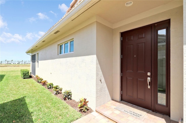 26047 SW Viterbo Way, Port St Lucie, FL 34986 - property entrance featuring stucco siding and a lawn